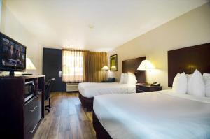 a hotel room with two beds and a flat screen tv at Hotel Monreale Express & Studios IDrive District in Orlando