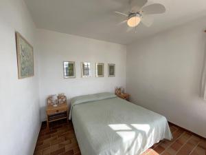 a bedroom with a bed and a ceiling fan at ES CASTELL 1 1 by SOM Menorca in Fornells