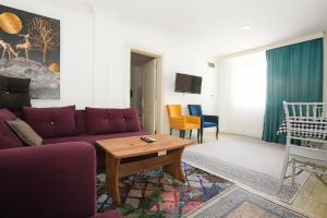 a living room with a purple couch and a table at Hillside Apart House in Side