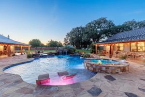 a swimming pool with chairs and a building at Bent Oak Highland Ranch and Concierge Services in Burnet