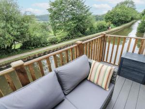 a couch on a balcony with a view of a river at Millside View in Keighley