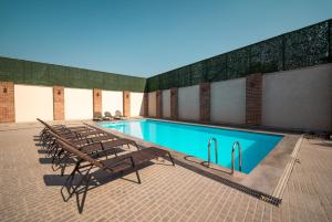 a swimming pool with a bunch of chairs next to it at Hotel Piano Kvareli in Kvareli