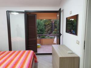 a bedroom with a bed and a sliding glass door at Ranieli Apartments a meno di 2 kilometri da TROPEA FREE PARKING AND WIFI in Drapia +44 photos