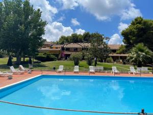 a large swimming pool with chairs and a building at Ranieli Apartments a meno di 2 kilometri da TROPEA FREE PARKING AND WIFI in Drapia