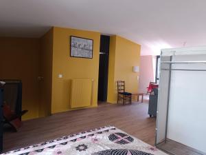 a living room with yellow walls and wooden floors at Grand studio confortable et calme in Arcueil