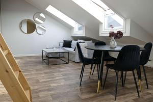 a dining room with a table and chairs and a couch at The Nordic Loft in Oslo