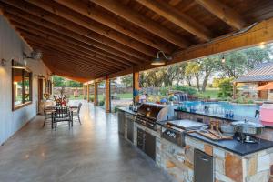 an outdoor kitchen with a pool in the background at Bent Oak Highland Ranch and Concierge Services in Burnet