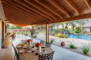 a patio with a table and chairs and a pool at Bent Oak Highland Ranch and Concierge Services in Burnet