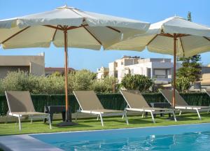 Un grupo de sillas y sombrillas junto a una piscina. en Villa Haris, en Kokkíni Khánion