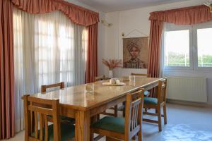 Un comedor con mesa y sillas de madera. en Villa Haris, en Kokkíni Khánion
