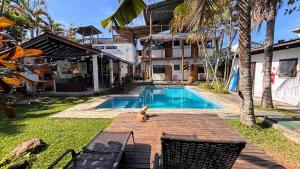 a dog sitting next to a swimming pool at Makai Suites in Ubatuba
