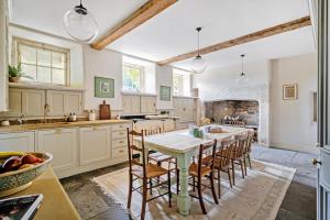 a kitchen with a table and chairs and a fireplace at Batheaston House in Bath