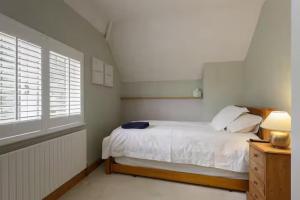 ein Schlafzimmer mit einem weißen Bett und einem Fenster in der Unterkunft Rogate Cottage Retreat in Petersfield + 34 Fotos