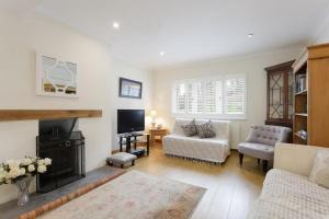 ein Wohnzimmer mit Couch und Kamin in der Unterkunft Rogate Cottage Retreat in Petersfield