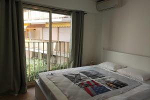 a bedroom with a bed and a window with a balcony at Les Clés d'Or d'Antibes in Antibes