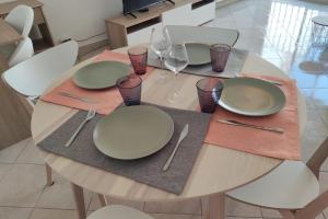 a dining room table with plates and wine glasses at Les Clés d'Or d'Antibes in Antibes