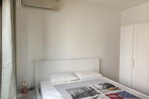 a white bedroom with a bed and a white wall at Les Clés d'Or d'Antibes in Antibes