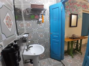 a bathroom with a blue door and a sink at Mina Café & Stay in Quan Lạn