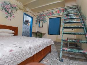 a bedroom with a bed with a ladder next to it at Mina Café & Stay in Quan Lạn