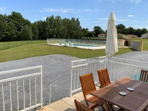 a patio with a table and an umbrella and a pool at Cheroulier in Laujuzan