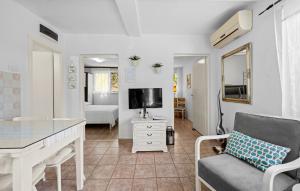 a living room with a couch and a desk and a tv at Regina Apartments in Brodarica