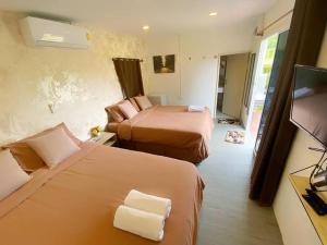 Una habitación de hotel con dos camas y un televisor. en วิวดี รีสอร์ท เขาค้อ, en Ban Tha Phon