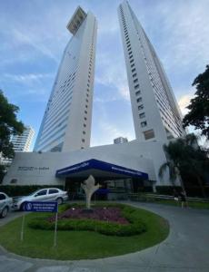 dos edificios altos con un coche aparcado delante en Excelente Flat Boa Viagem Andar Alto, en Recife