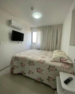 Un dormitorio con una cama y un televisor. en Excelente Flat Boa Viagem Andar Alto, en Recife