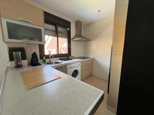 a kitchen with a sink and a washing machine at Luminoso y Elegante, piscinas y pistas de pádel in Palm-mar +28 photos