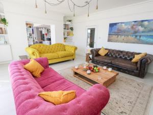Sala de estar con sofá púrpura y mesa de centro en The Beach Condo, en Weymouth