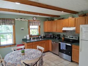eine Küche mit Holzschränken und einem Tisch und einem Tisch und einem Tisch in der Unterkunft Bear Valley - Riverfront, Starlink WiFi & Hot Tub in Luray
