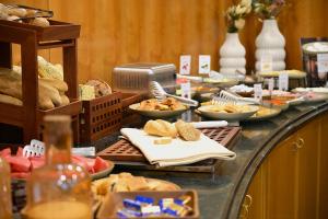 een buffet met brood en ander eten op een tafel bij Hotel Karpos in Skopje