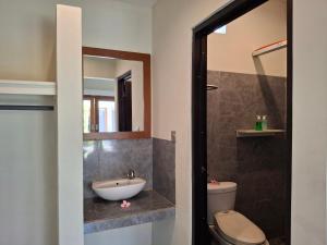 une salle de bain avec un lavabo et des toilettes dans l'établissement Sammy Cottage Senggigi, à Mangsit