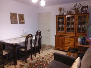 una sala da pranzo con tavolo, sedie e armadio di Casa Cătălina a Silvaşu de Jos