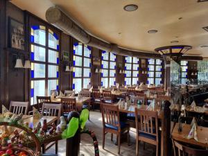 Un restaurante con mesas y sillas de madera y ventanas. en Ferienwohnung Rheinaue, en Colonia