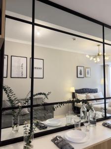 a mirror in a living room with a table with glasses at Mi Casa Baguio Exquisuite in Baguio