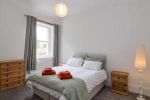 a bedroom with a bed with red towels on it at The Cottage in Clevedon