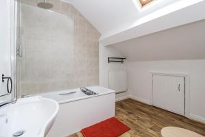 a bathroom with a white sink and a red rug at The Cottage in Clevedon +12 photos