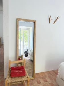 a mirror in a room with a chair and a bed at Danna Portuguese Design House Porta 10 in Tavira