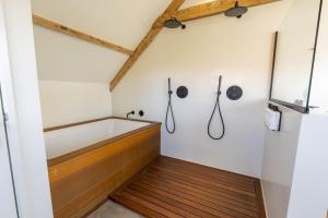 a bathroom with a tub and a wooden floor at Van Heeckeren Apartments & Suites Buren in Buren +22 photos