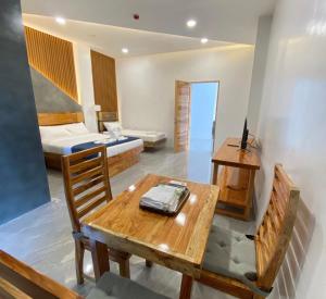 a room with a table and a bed and a desk at AC Cosy Hotel in Lala