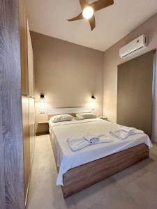 a bedroom with a bed and a ceiling fan at Golden Beach Apartments in Chrysi Ammoudia