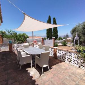 eine Terrasse mit Tisch und Stühlen und einem Zaun in der Unterkunft Villa Namaste in Alhaurín de la Torre