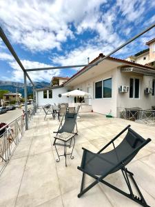a patio with chairs and an umbrella and a house at Golden Beach Apartments in Chrysi Ammoudia