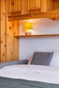 a bedroom with a bed with a lamp on it at Cosy Apartment In Heart of Val Thorens, Ski In-Out with WiFi in Val Thorens