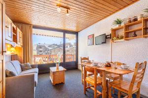 a living room with a table and a couch at Cosy Apartment In Heart of Val Thorens, Ski In-Out with WiFi in Val Thorens