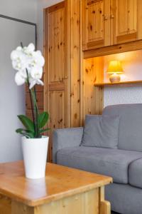 a living room with a couch and a table with a flower at Cosy Apartment In Heart of Val Thorens, Ski In-Out with WiFi in Val Thorens