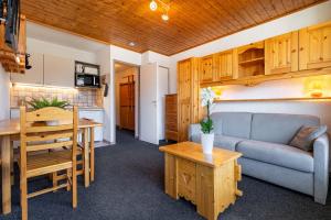 a living room with a couch and a table at Cosy Apartment In Heart of Val Thorens, Ski In-Out with WiFi in Val Thorens