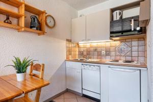 a kitchen with white appliances and a wooden table at Cosy Apartment In Heart of Val Thorens, Ski In-Out with WiFi in Val Thorens +6 photos