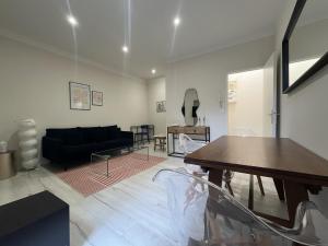 a living room with a black couch and a table at Appartement 2 personnes - Angers in Angers